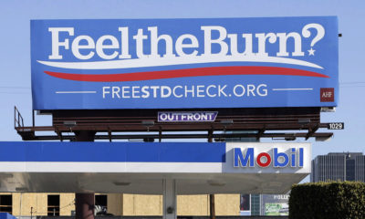 A billboard above a gas station that reads "Feel The Burn," actually promotes free STD testing.