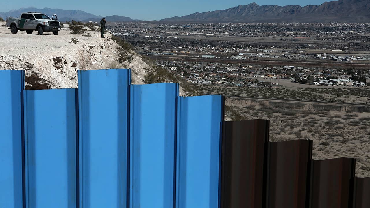 Photo of border fence and border patrol agent in New Mexico