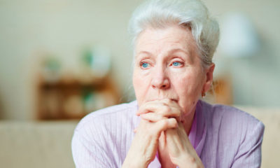 Older woman gazes off into the distance.