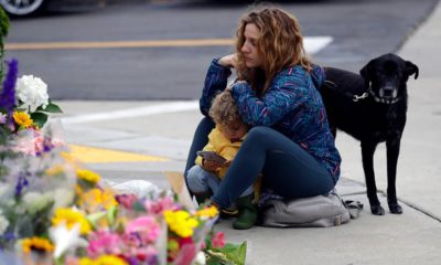 Photo of woman sitting at a memorial for the Chabad of Poway synagogue