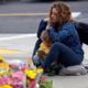 Photo of woman sitting at a memorial for the Chabad of Poway synagogue