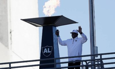 Photo of Cliff Branch lighting a memorial flame in honor of Al Davis.