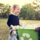 Photo of two young girls holding a recycling bin