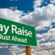 Composite image of a pay raise ahead sign and blue skies