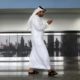 Photo of a worker looking at his phone at the airport in Dubai