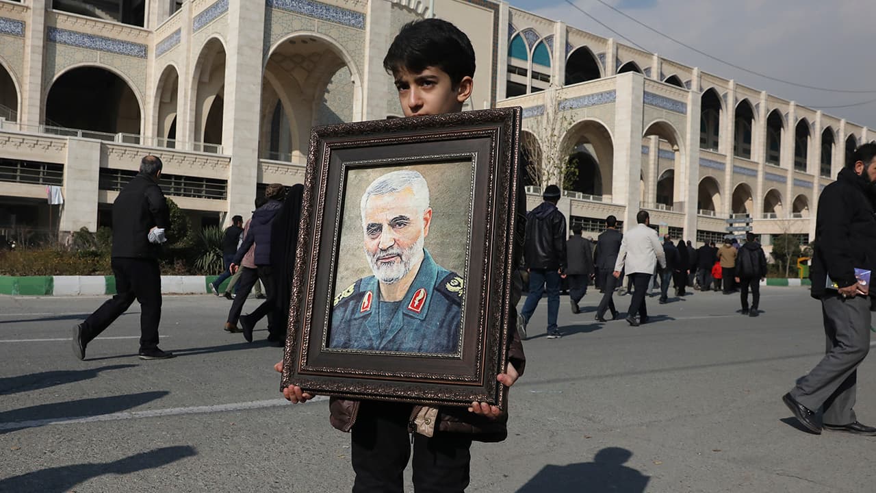 Photo of a boy holding a portrait of Iranian Revolutionary Guard Gen. Qassem Soleimani, who was killed in the U.S. airstrike in Iraq