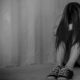 Photo of a sad young woman sitting in a room on the floor