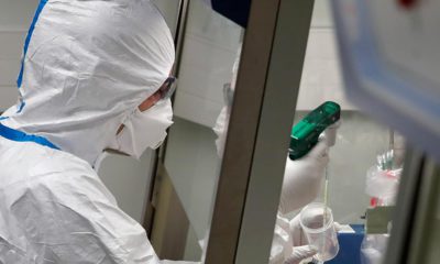Photo of a French lab scientist in hazmat gear